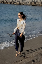 a lady in a map printed silk shirt and a pair of grey pants